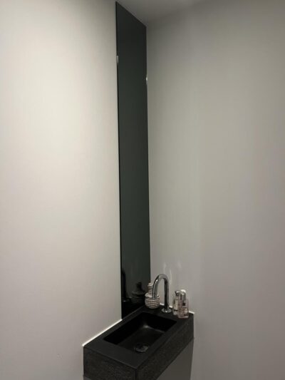 Miroir long et étroit au-dessus du lavabo. Collé dans les toilettes