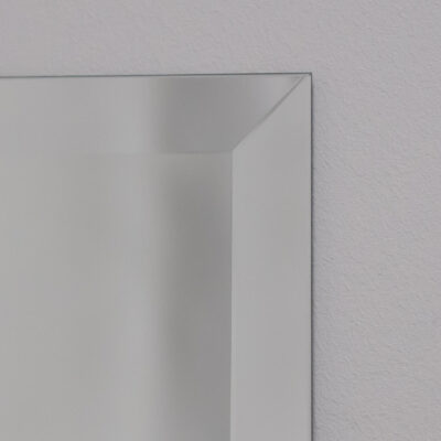 Miroir taillé à facettes dont on voit l'arête de près. Le miroir est de couleur argentée standard